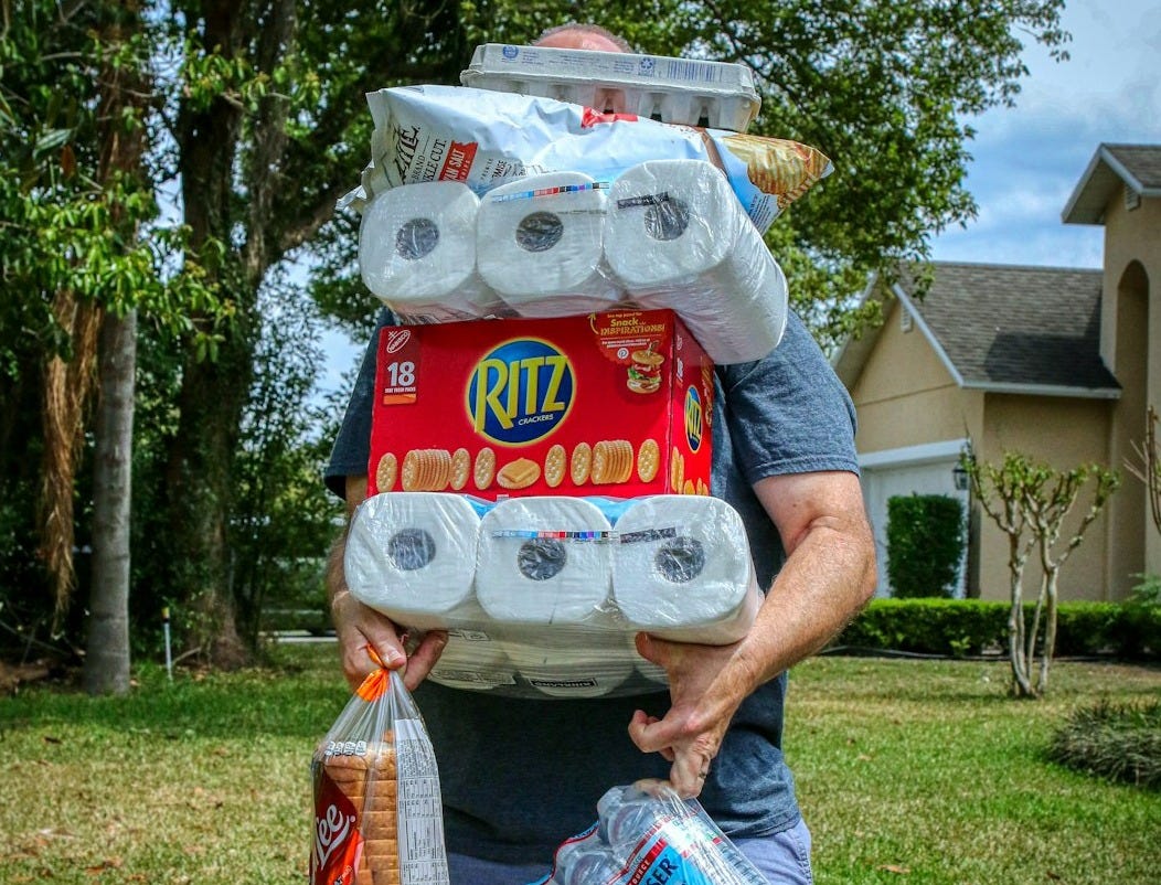 person holding white and red plastic pack person holding white and red plastic pack