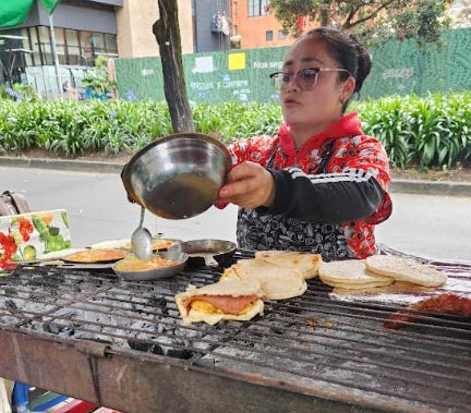 Street vendor in Bogotá making arepas.