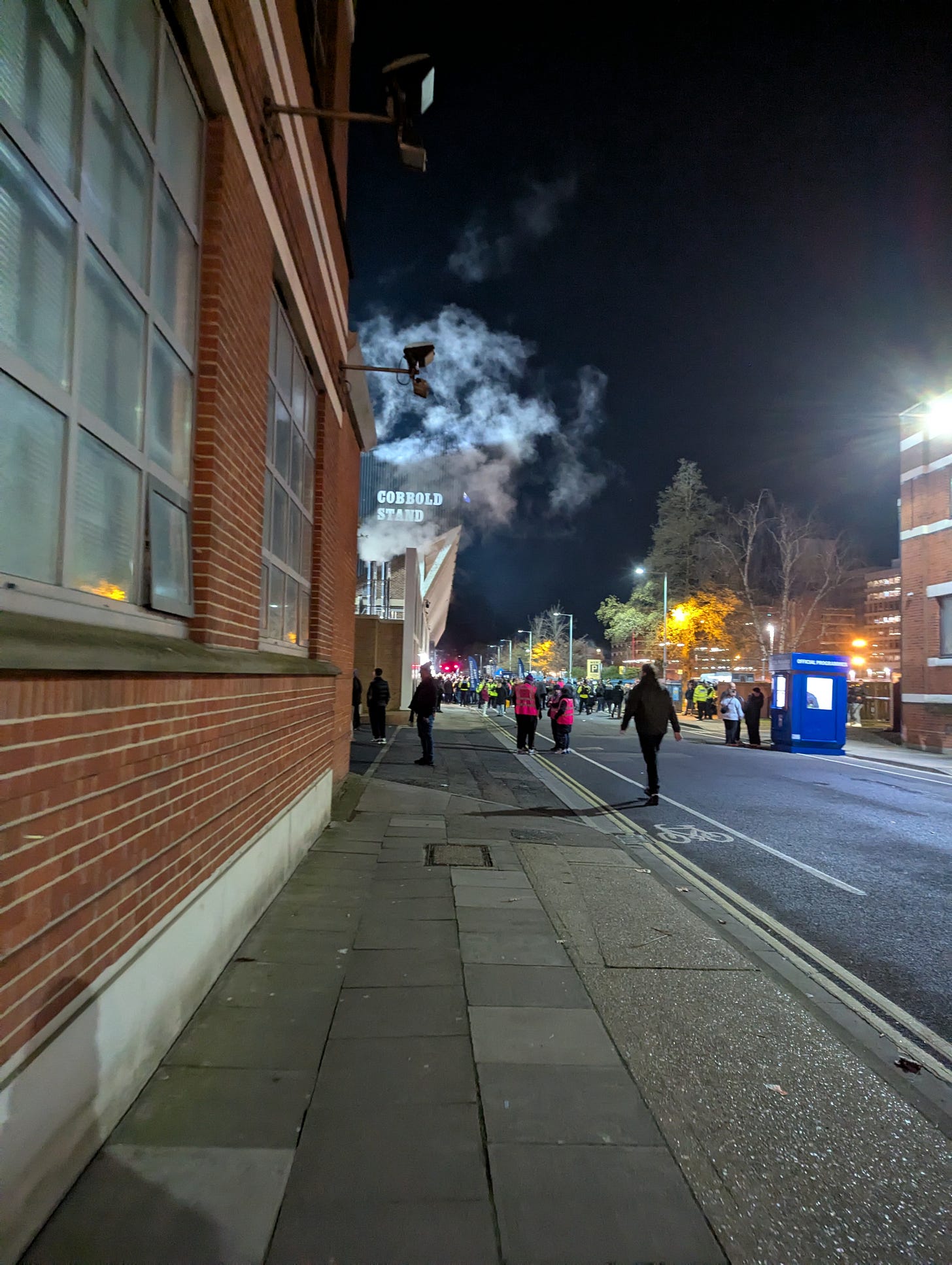 View of Portman Road looking North. Fans are streaming up the road, a vent is open partially covering the words "Cobbold Stand" written on the nearest stand