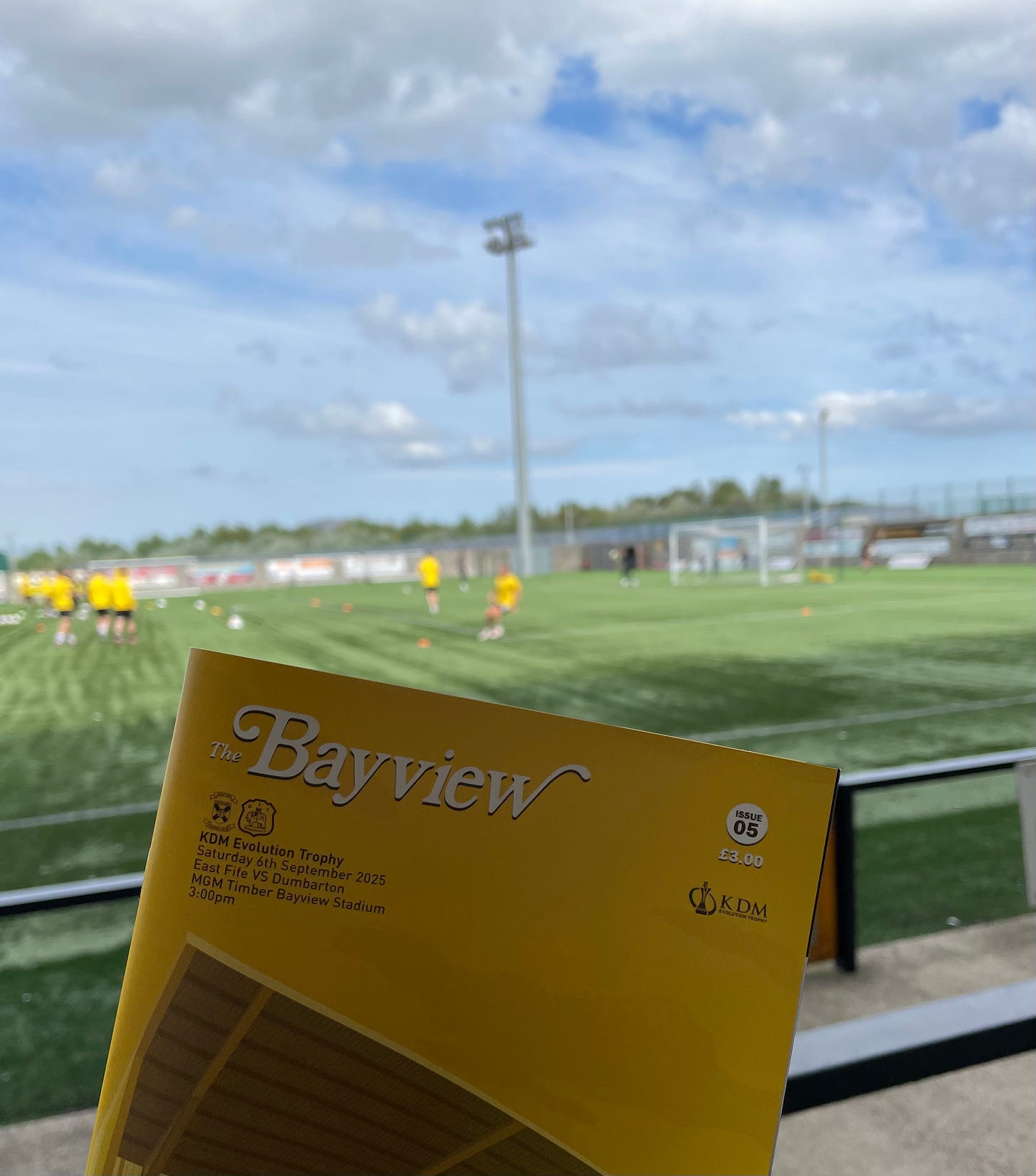 The programme for East Fife vs. Dumbarton, with the pitch in the background