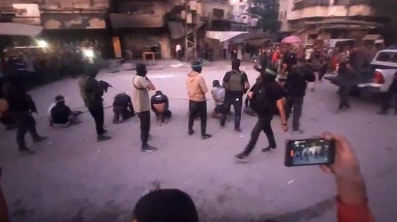 An image from a video released by the Hamas-run al-Aqsa TV's Telegram channel shows Hamas fighters in the moments before a public execution on Monday on a street in Gaza City.