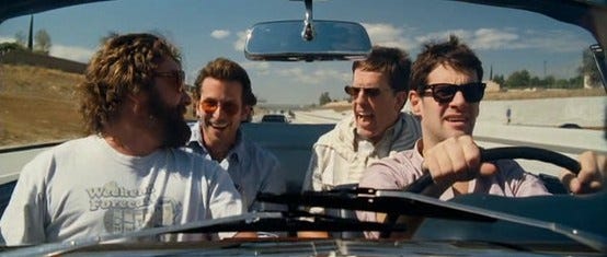 This may contain: three men are sitting in a car and one is pointing at the other man's head This may contain: three men are sitting in a car and one is pointing at the other man's head