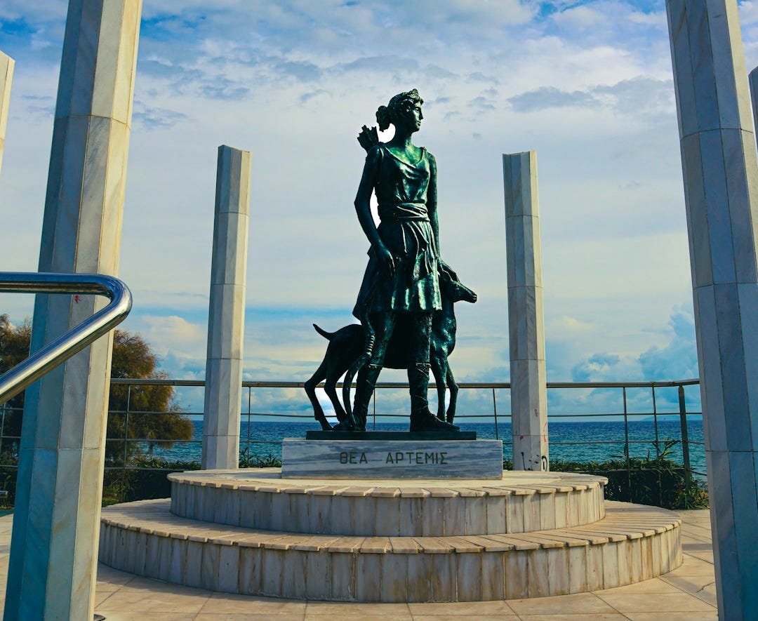 Statue of a woman with a dog by the sea