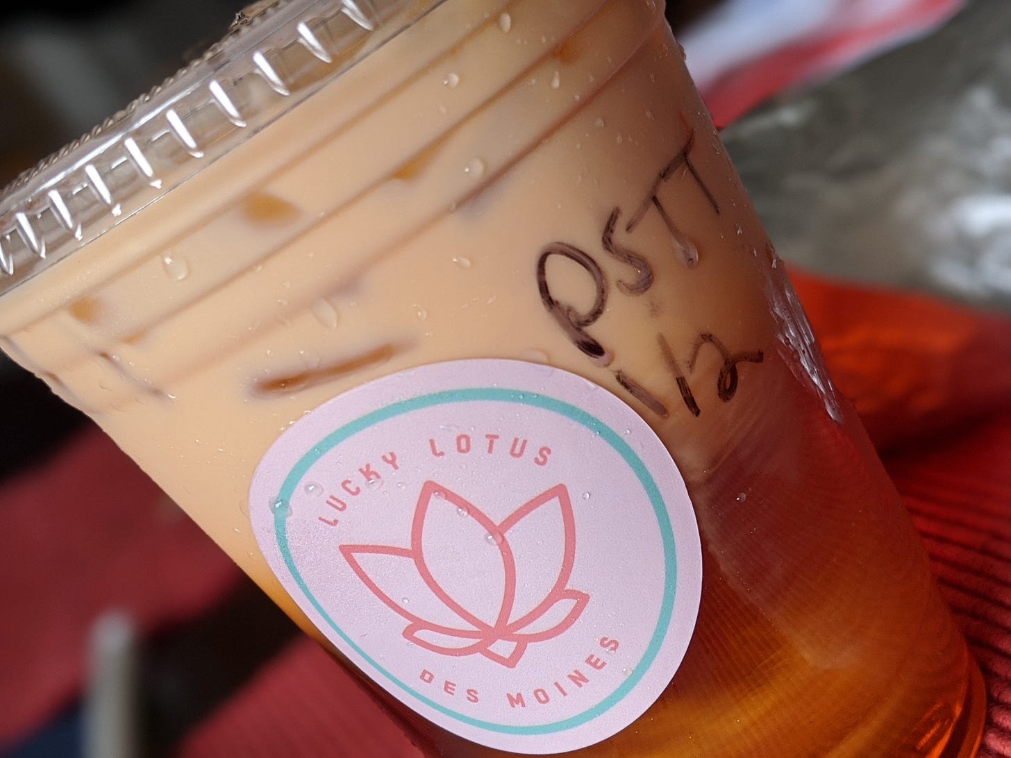 A close up of a to-go cup of pumpkin spice Thai tea from Lucky Lotus.