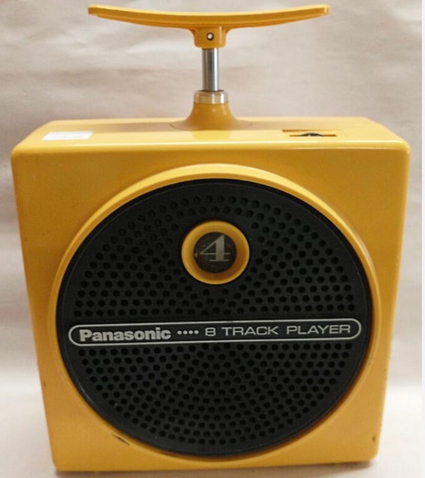 picture of a Panasonic "Dynamite" 8-track player, in bright yellow and with a plunger on top and a round black face. All circa 1970 (at least mine was).