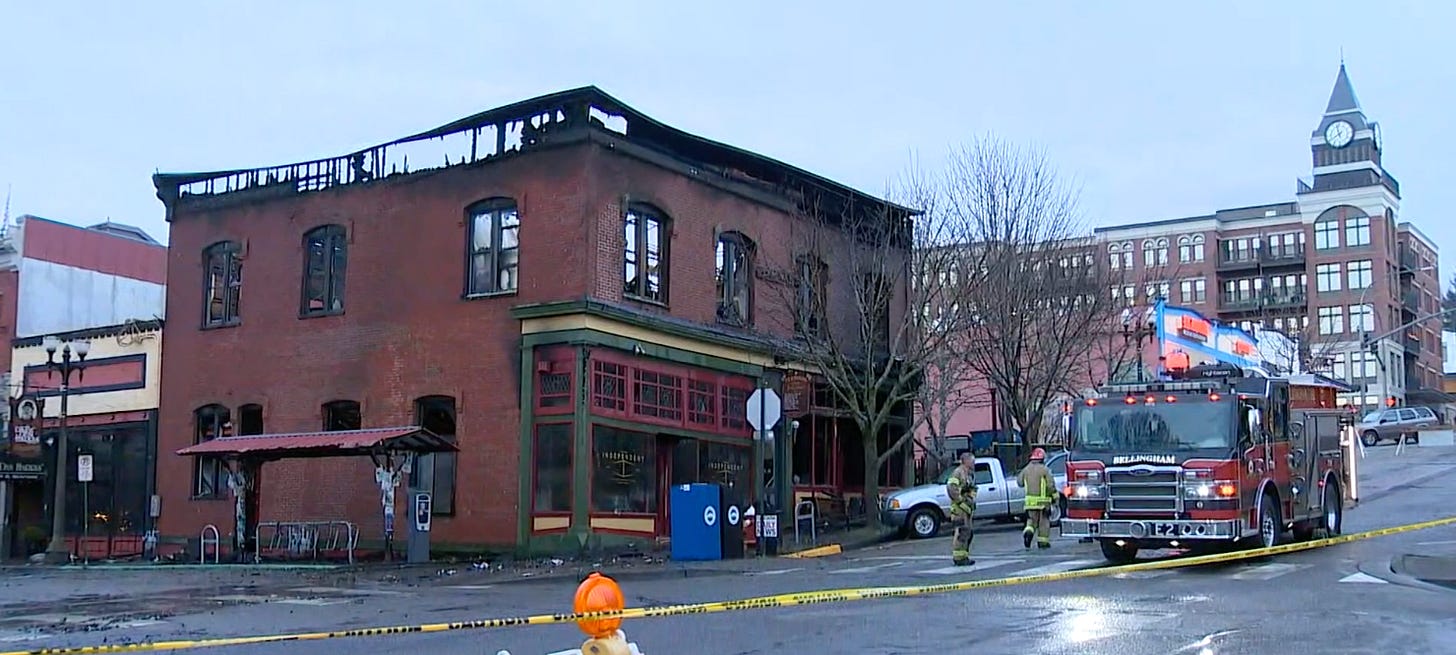 Fire ravaged termial building the next day, firetruck outside with firefighters 