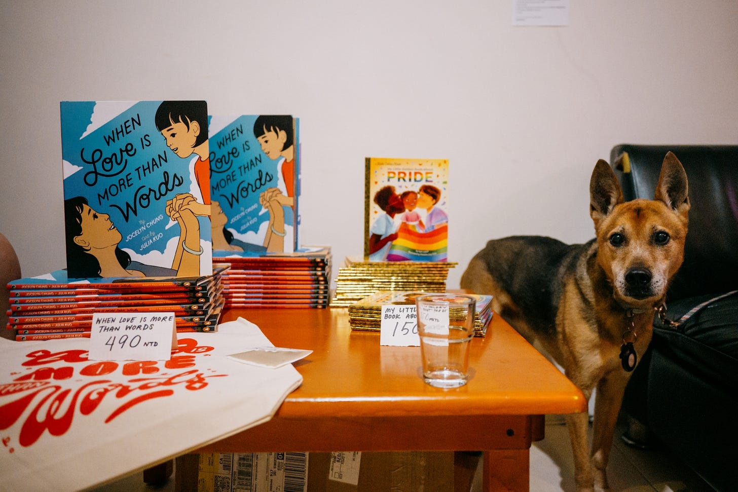 Photo of a dog in front of books and merchandise from a storytime and Q+A event with Jocelyn Cheung and Michelle Jing Chan.
