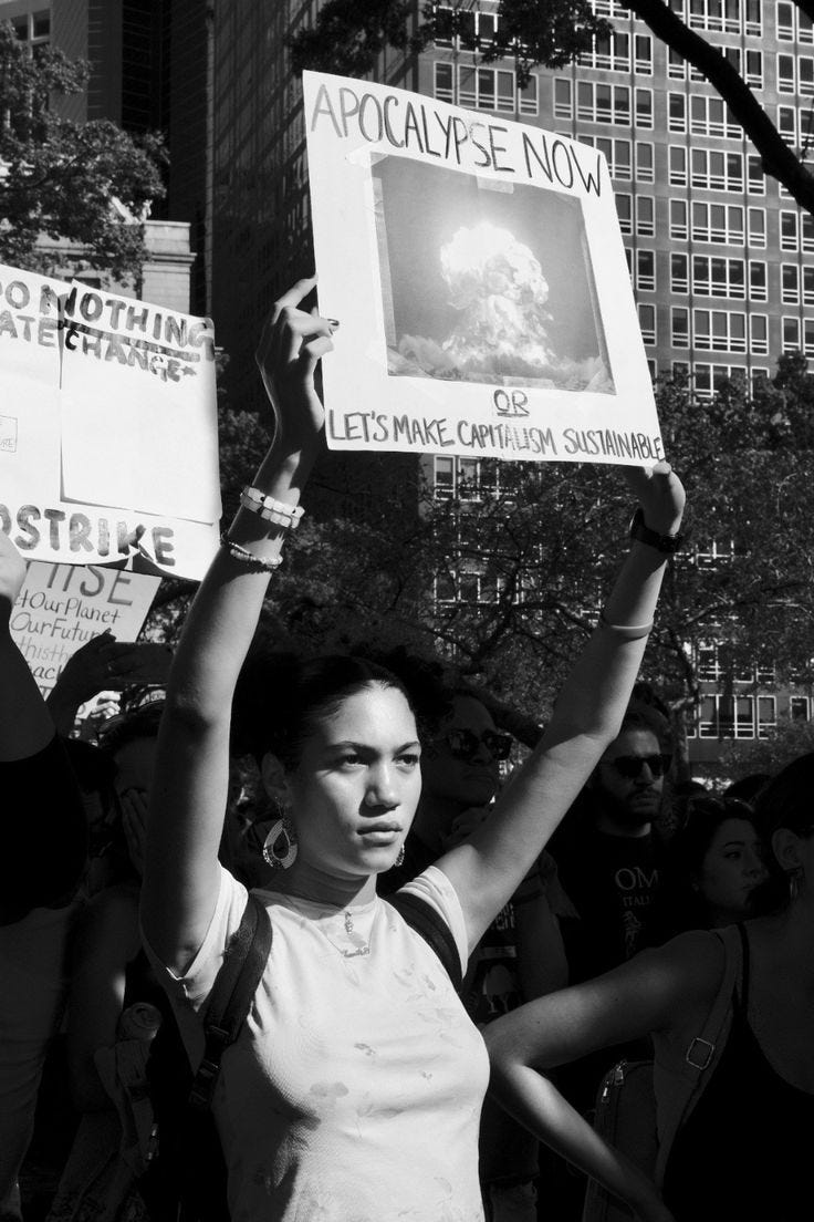 This may contain: a woman holding up a sign in the air This may contain: a woman holding up a sign in the air