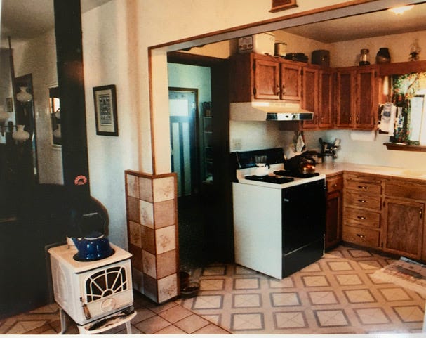 Kitchen with white walls and wooden cupboard doors.