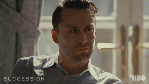 A man with a worried expression from HBO's 'Succession' series, dressed in a light button-up shirt, with the show title and HBO logo displayed at the bottom of the frame