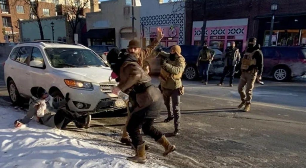 Alex Pretti, one had on phone, one hand in the air, moments before getting shot to death by Border Patrol agents.
