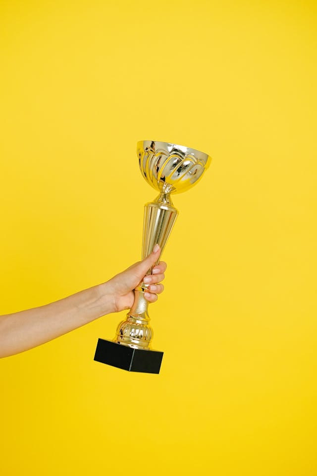 A person holding a trophy with one hand A person holding a trophy with one hand