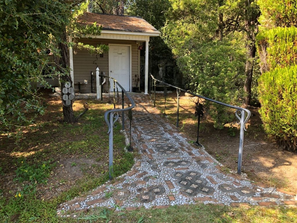 A small shed and walkway at the rear of the Pearl Fryar Topiary Garden house