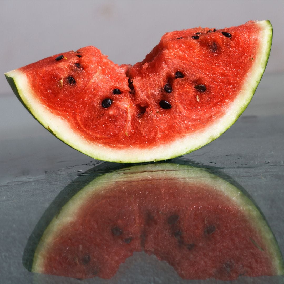 closeup pic of a watermelon slice with a bite taken out of it, via Canva
