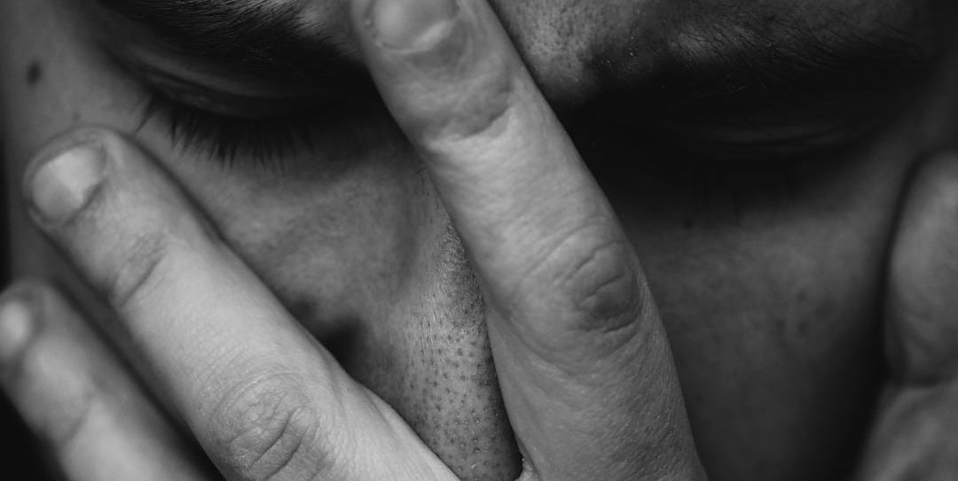 grayscale photo of person placing hand on face grayscale photo of person placing hand on face