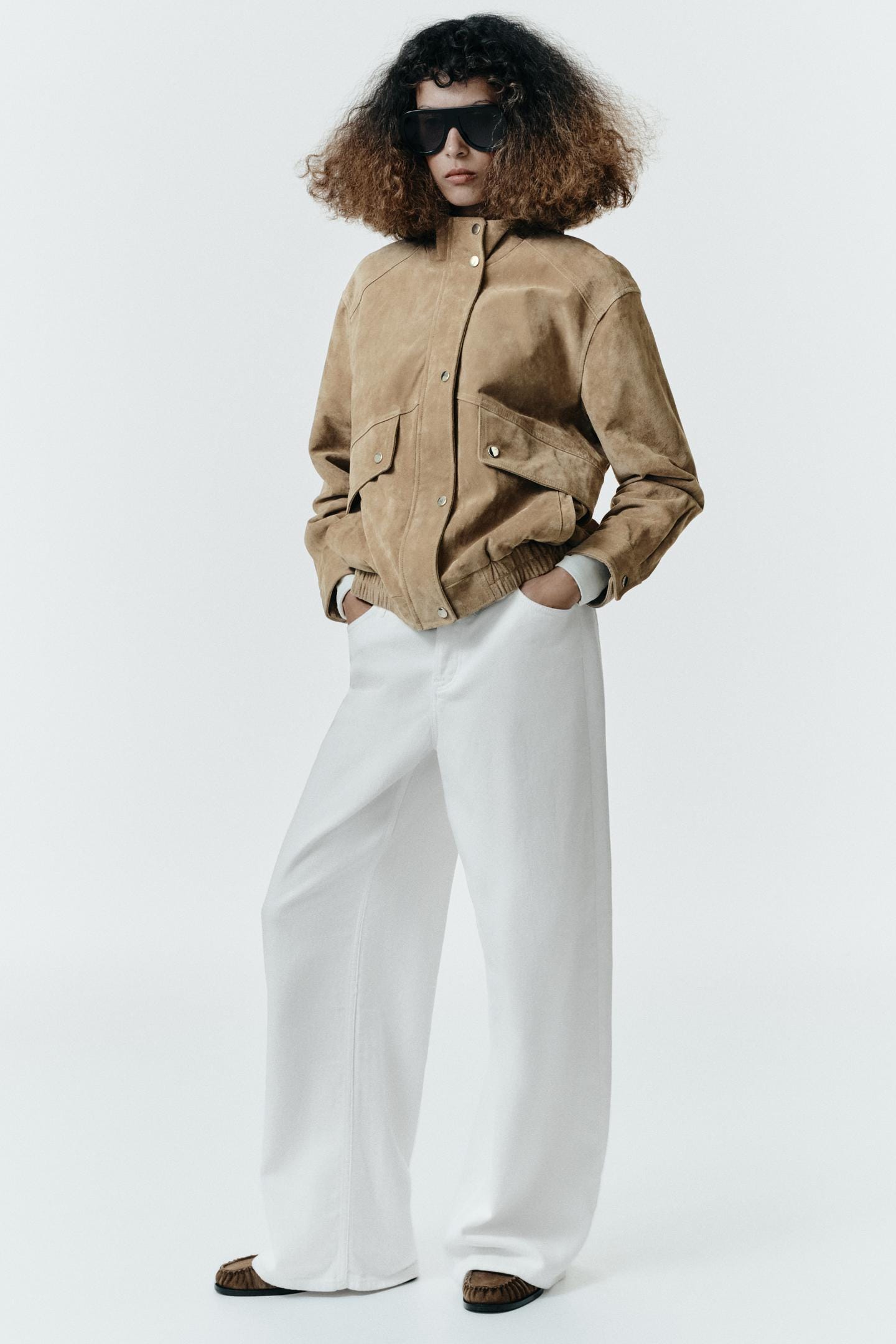 Beige jacket set with front pockets and wide white trousers.