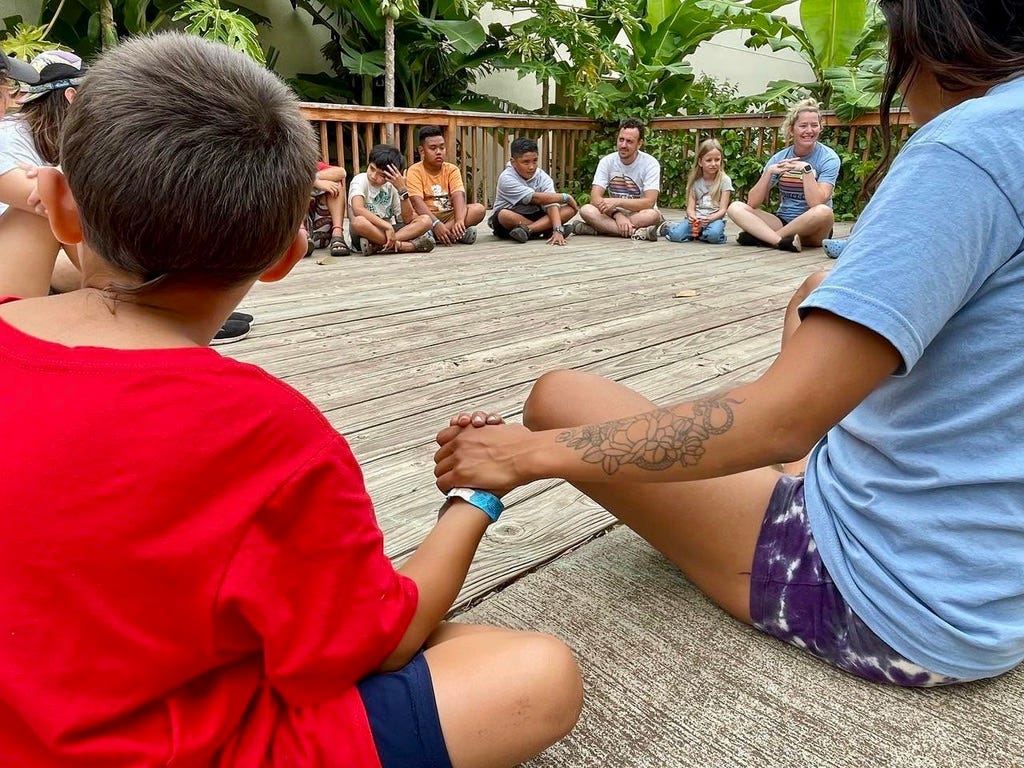 Campers and camp volunteers sitting in a circle