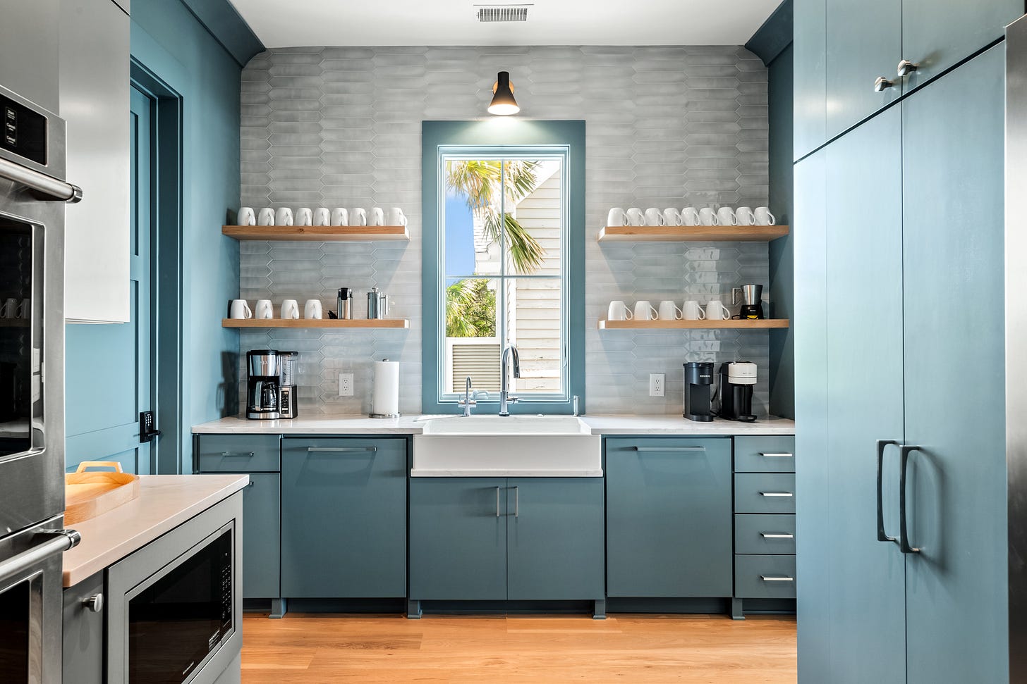A blue green working pantry with lots of cabinets and a coffee station wall. A blue green working pantry with lots of cabinets and a coffee station wall.