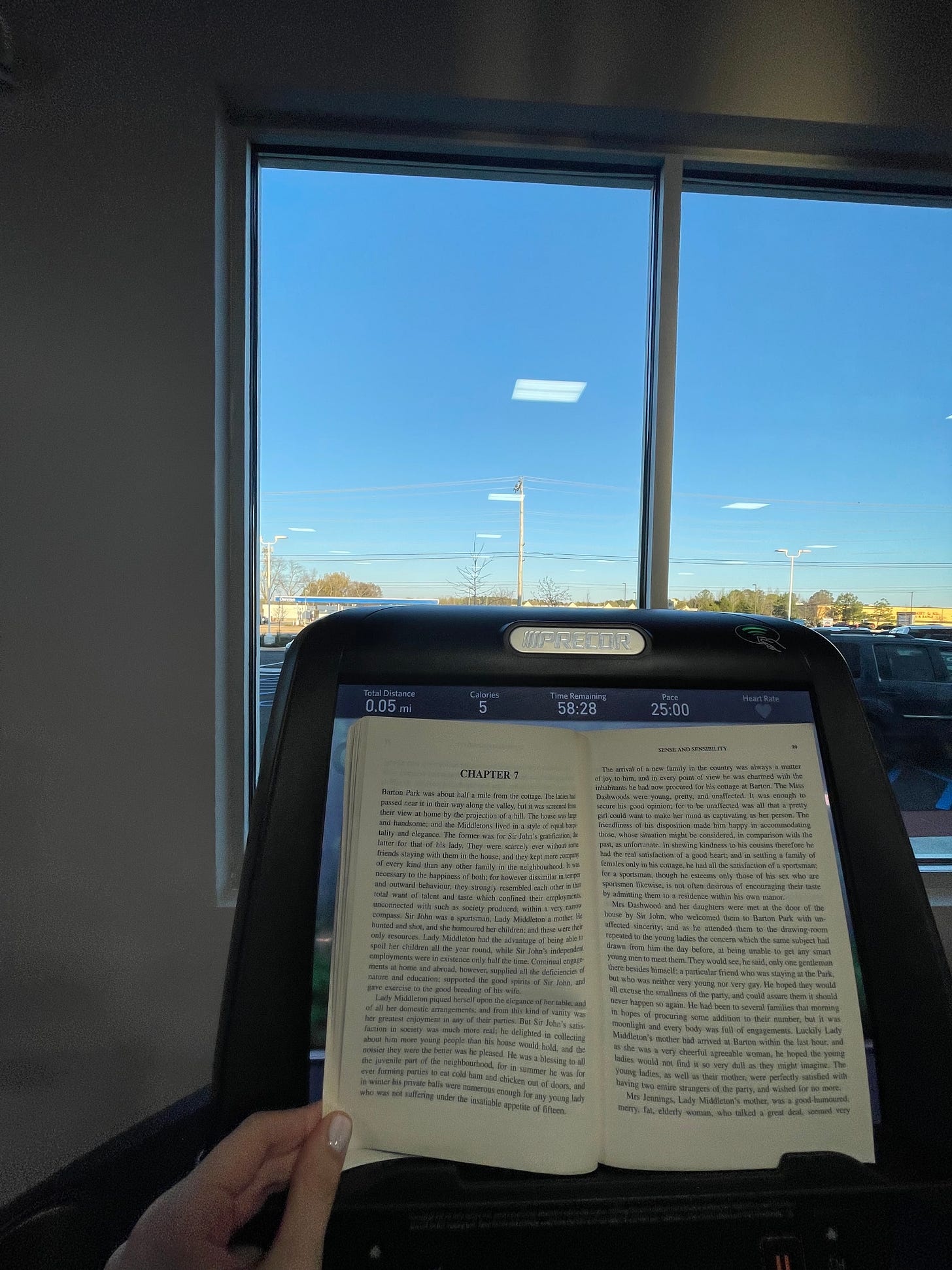 Image of a book open in front of the screen of a treadmill