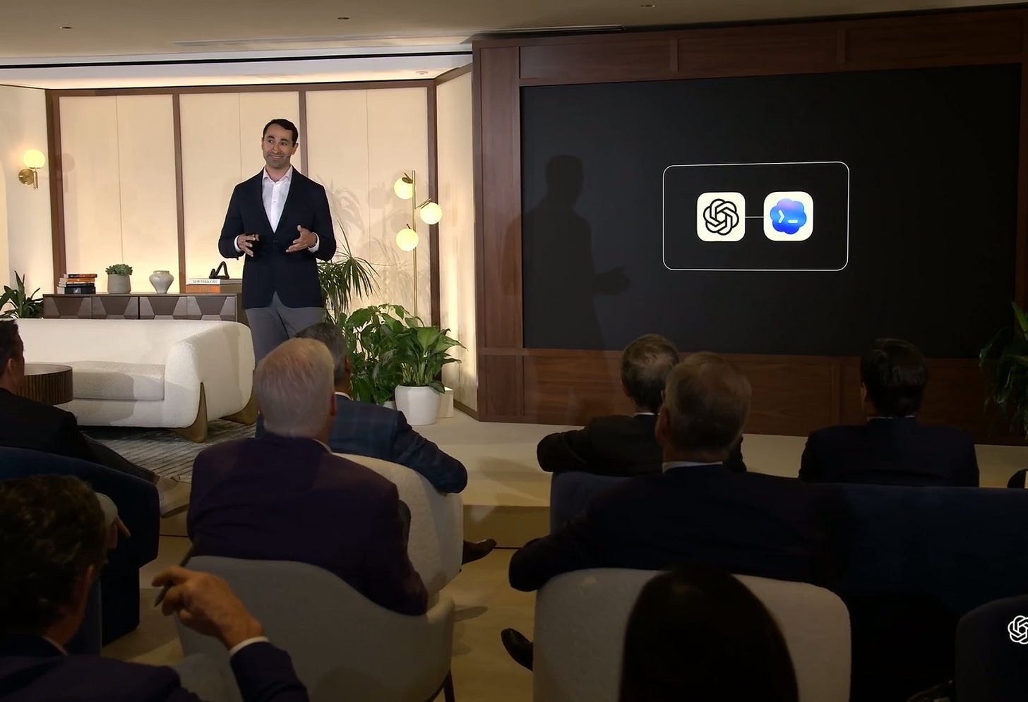 OpenAI's CRO in front of a presentation that shows the logos for ChatGPT and Codex