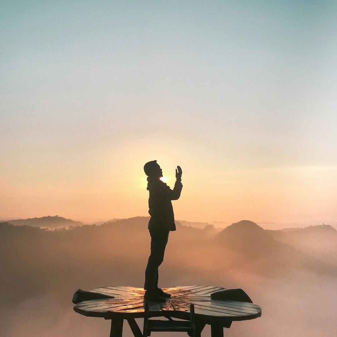 silhouette of praying man