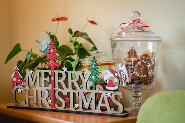 "Merry Christmas" sign next to a container of gingerbread cookies "Merry Christmas" sign next to a container of gingerbread cookies