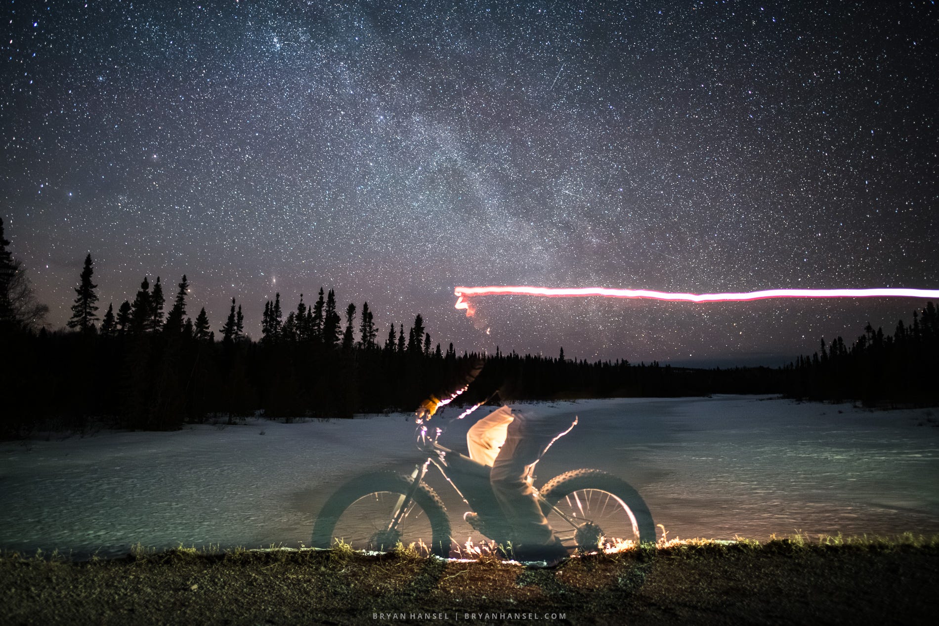A ghost biker rides against the northern night sky.