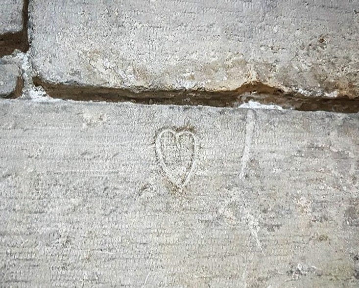 A heart carved into one of the stones that are a part of the ancient moat under the Louvre museum in Paris.