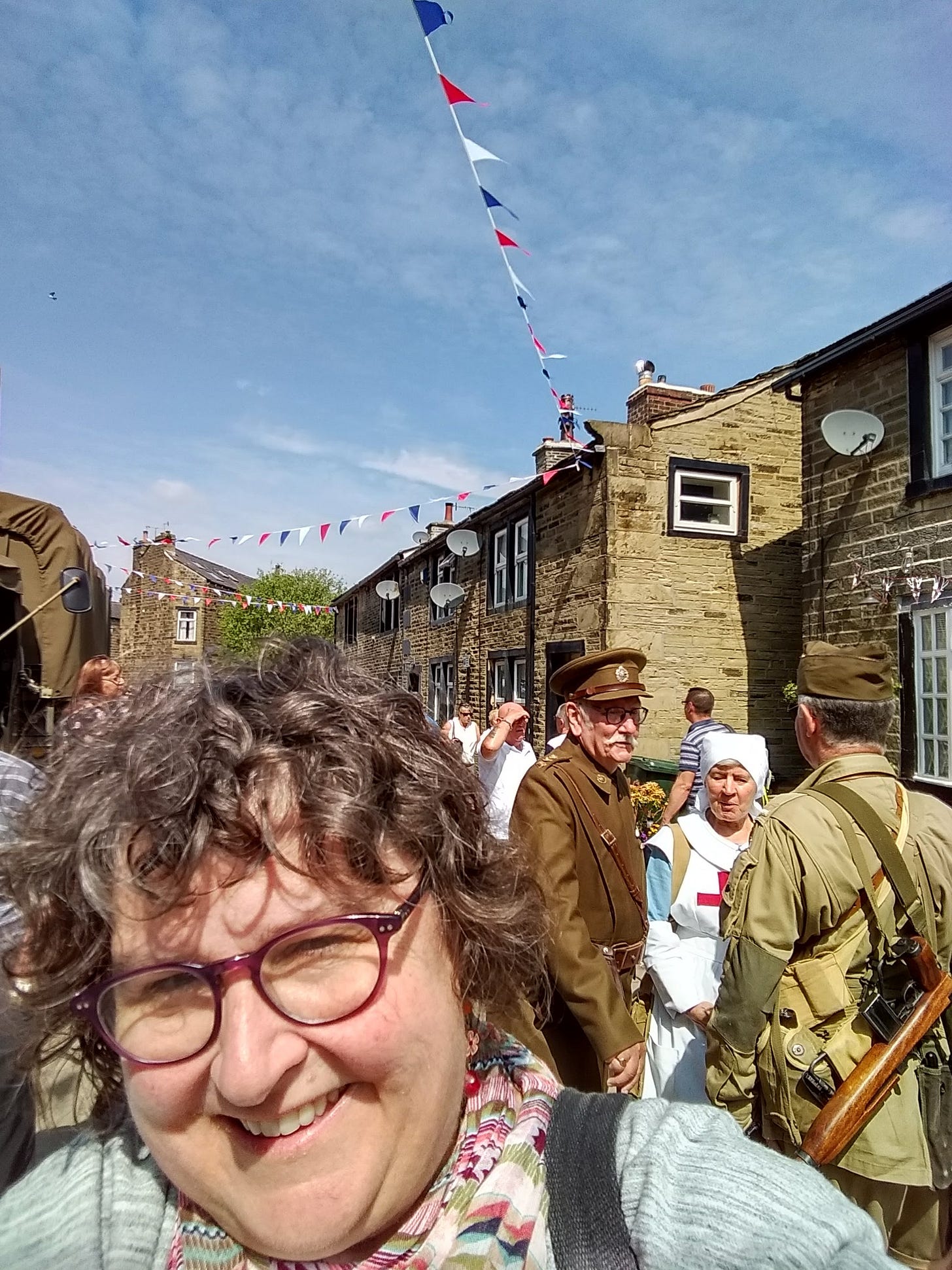 Annette on street in England with people dressed in military and civilian clothing from WWII