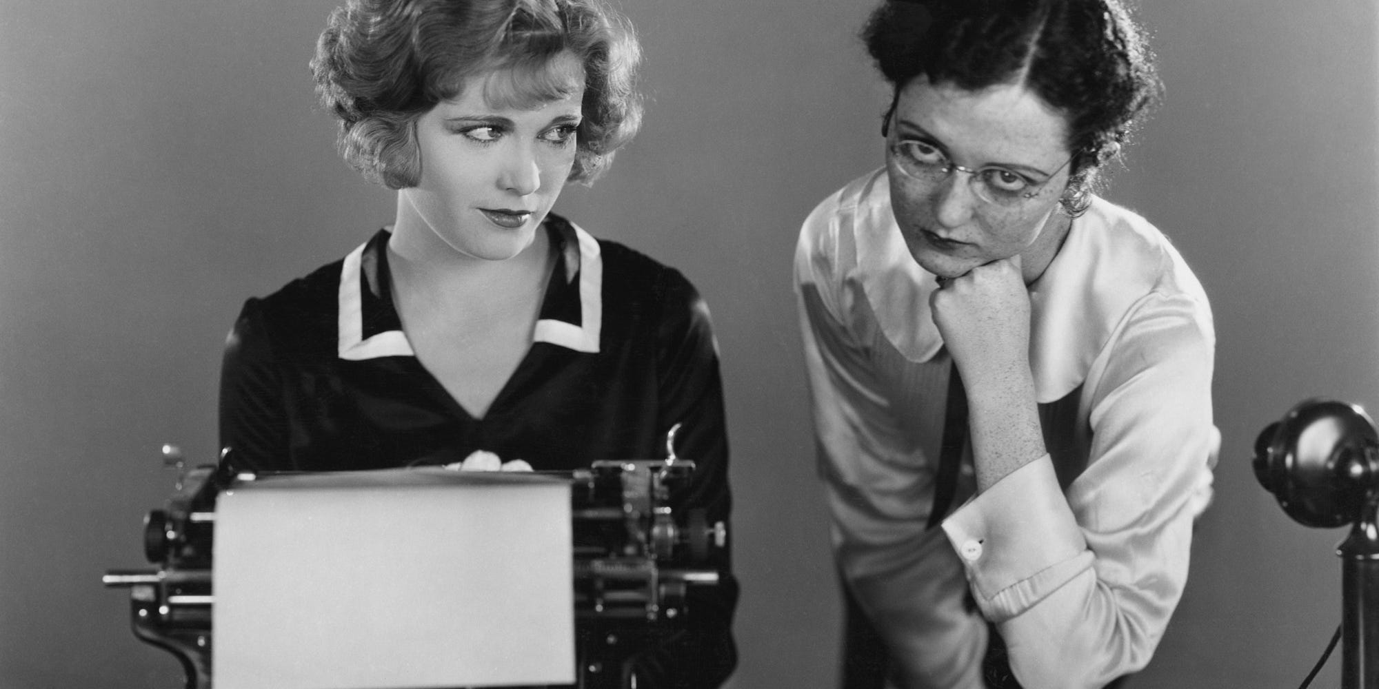Two women embarassed by what's on the typewriter representing concept of fear of showing your writing.