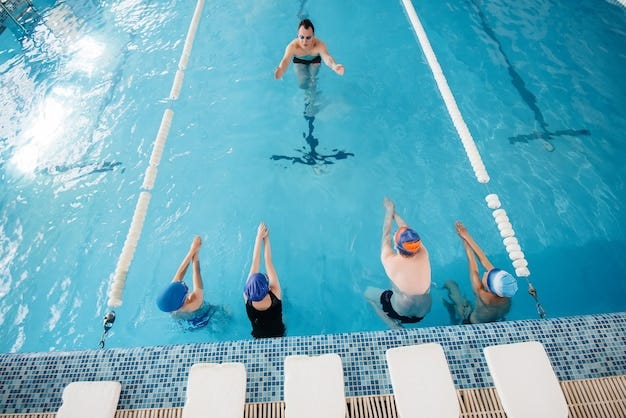 A group of boys and girls train and learn to swim in the pool with an instructor. Development of children's sports.