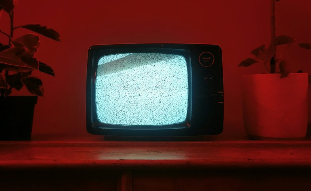 a small television sitting on top of a wooden dresser