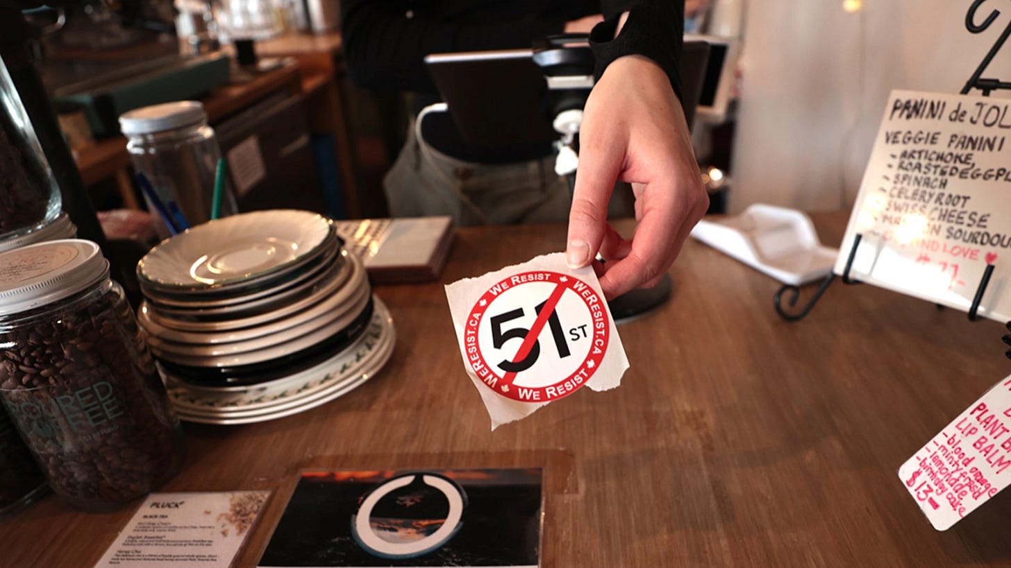 A barista hands out an anti-51st state sticker at a coffee shop in Toronto, Canada, on March 5, 2025. A barista hands out an anti-51st state sticker at a coffee shop in Toronto, Canada, on March 5, 2025.