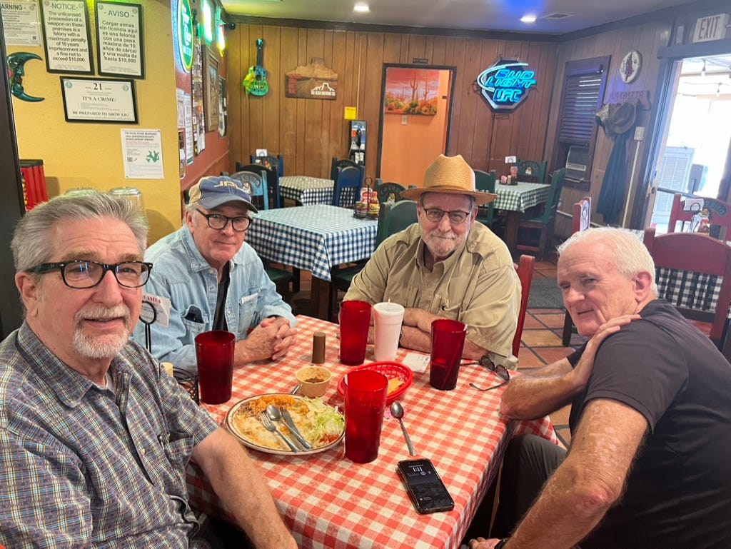 A group of men sitting at a table

Description automatically generated
