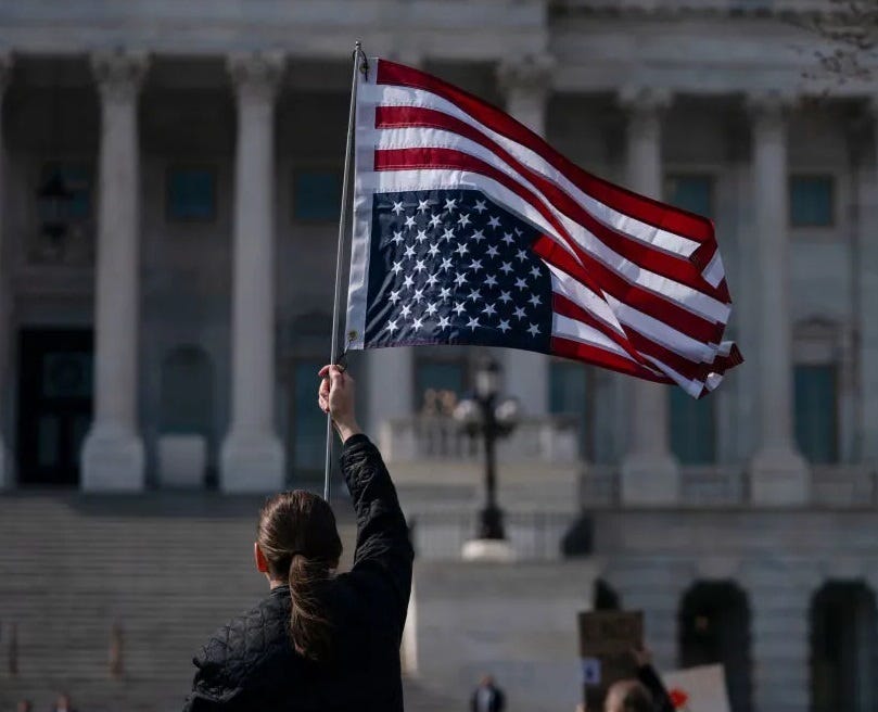 Man holidng upside down US flag