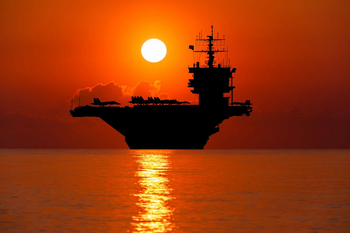 Aircraft carrier at sunset in the sea