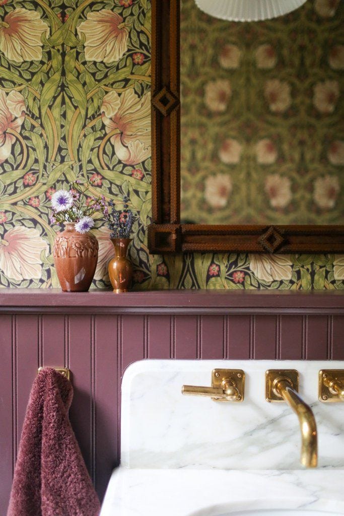 This may contain: a bathroom sink sitting under a mirror next to a wall mounted faucet with flowers on it This may contain: a bathroom sink sitting under a mirror next to a wall mounted faucet with flowers on it