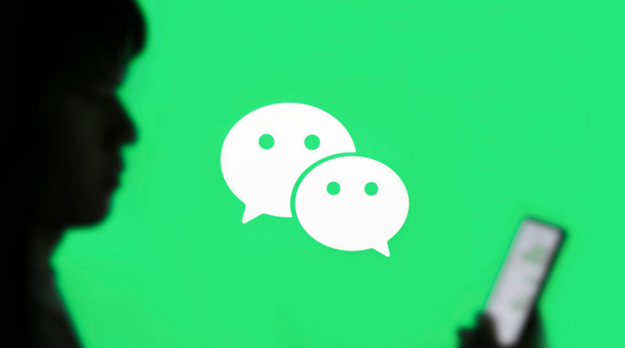 Silhouette of a person holding a smartphone against a WeChat logo on a green background.