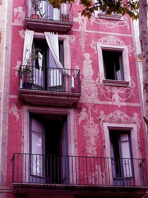 This may contain: a pink building with balconies and windows