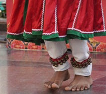 A barefooted dancer with bells on their ankles.