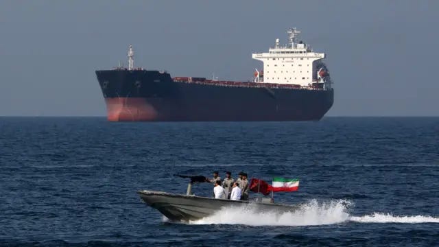 Un hors-bord militaire iranien passe devant un très grand pétrolier dans le détroit d'Ormuz le 30 avril 2019.