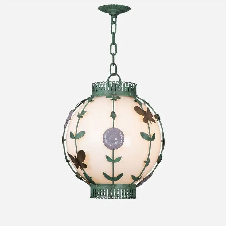 This may contain: a light hanging from a chain with flowers on it's glass globe shape shade