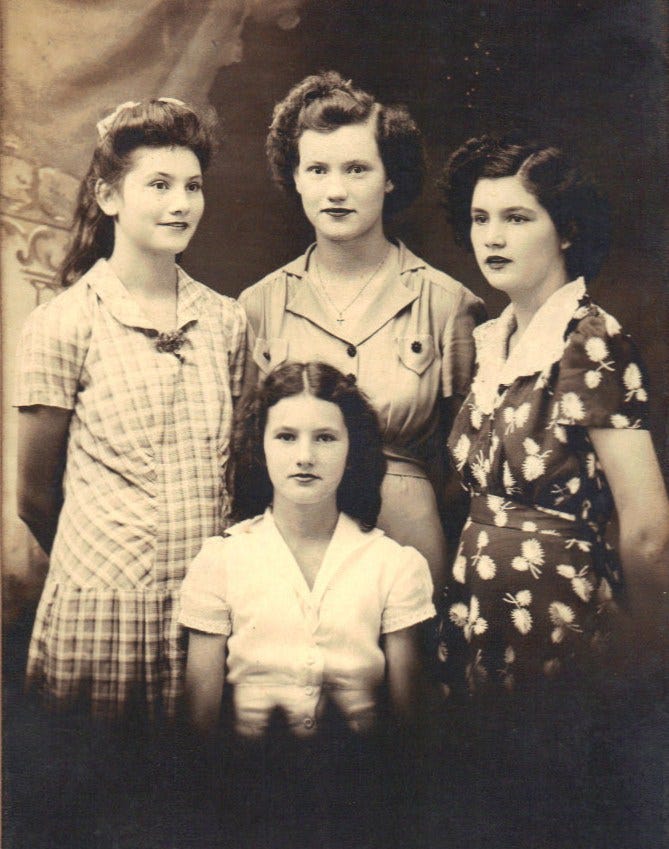Sepia-toned photo of four late teen, early adult daughters, three standing around the youngest seated