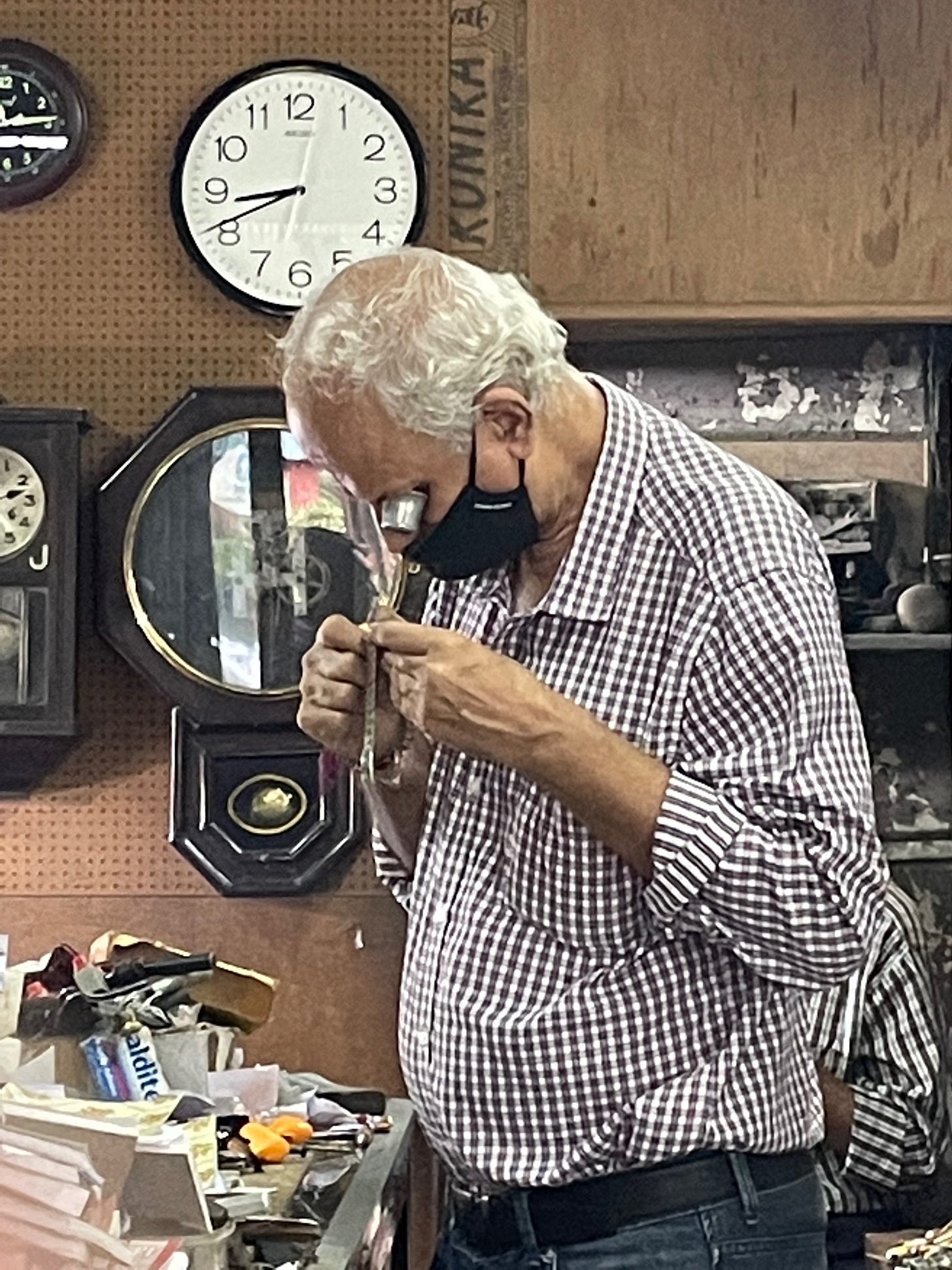 A person wearing a mask looking through a magnifying glass

Description automatically generated