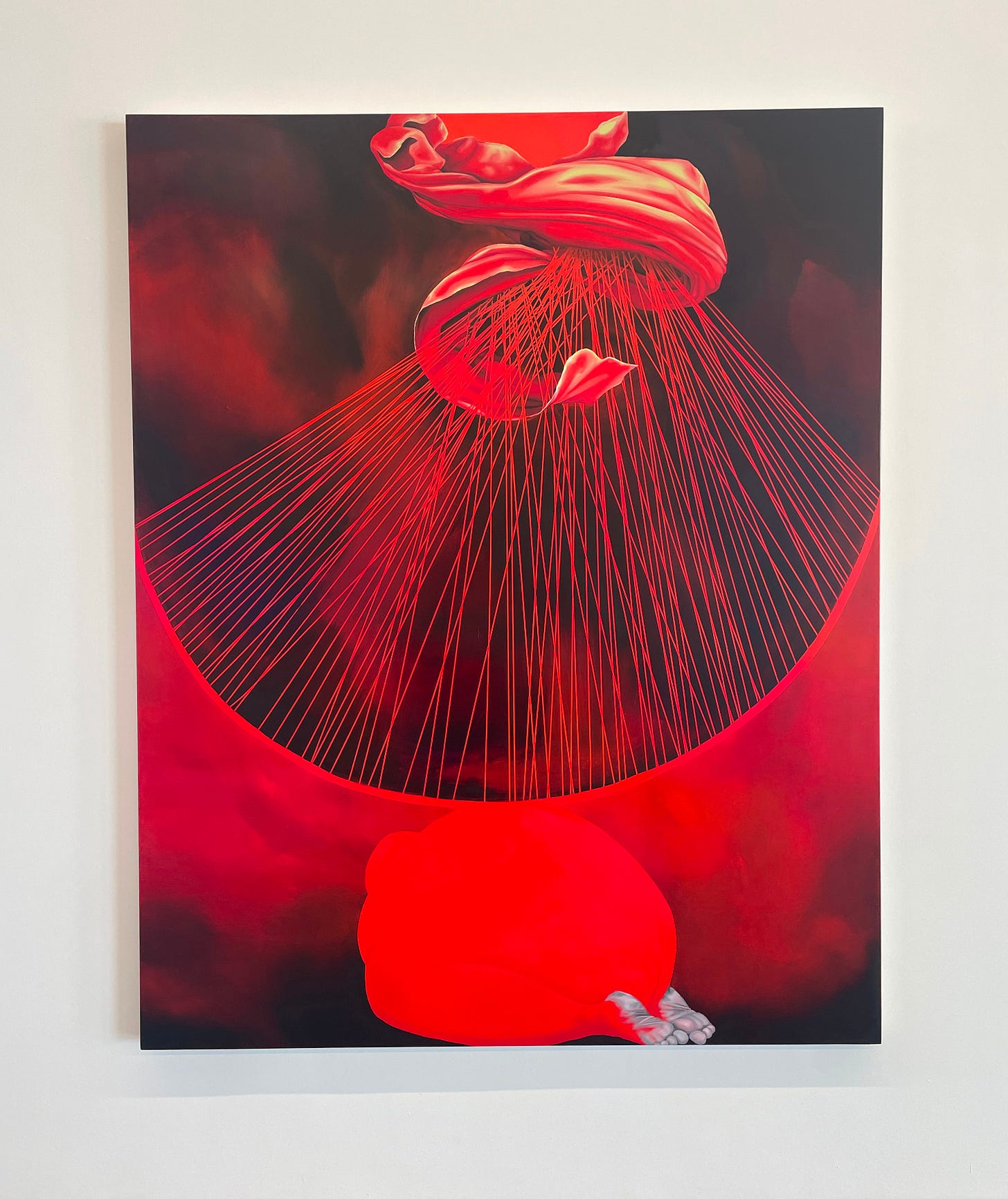 Red and black oil painting of a red garment radiating 100 rays of red light down onto a crouched red human figure with gray soles of their feet