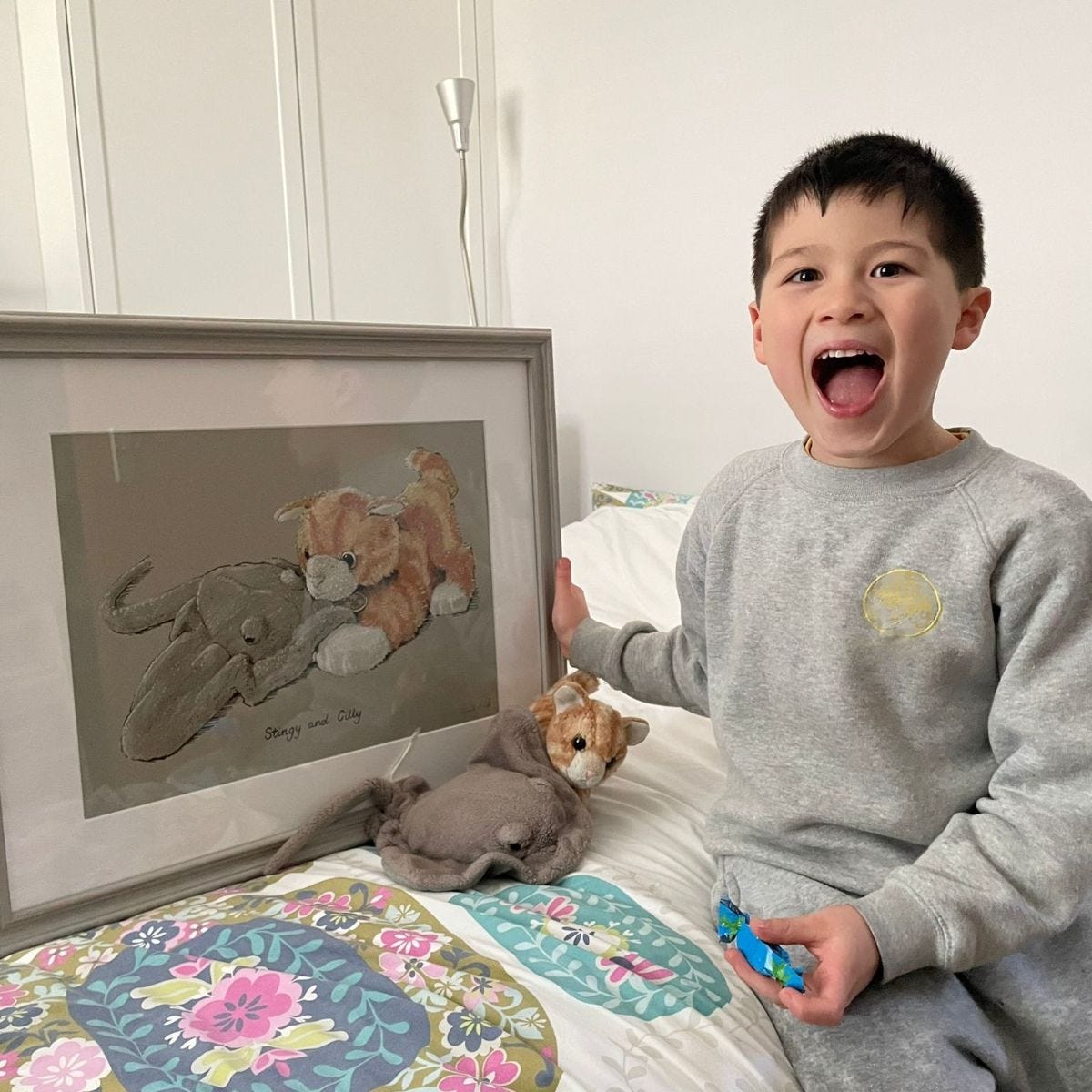 Very happy boy holding framed soft toy portrait Very happy boy holding framed soft toy portrait