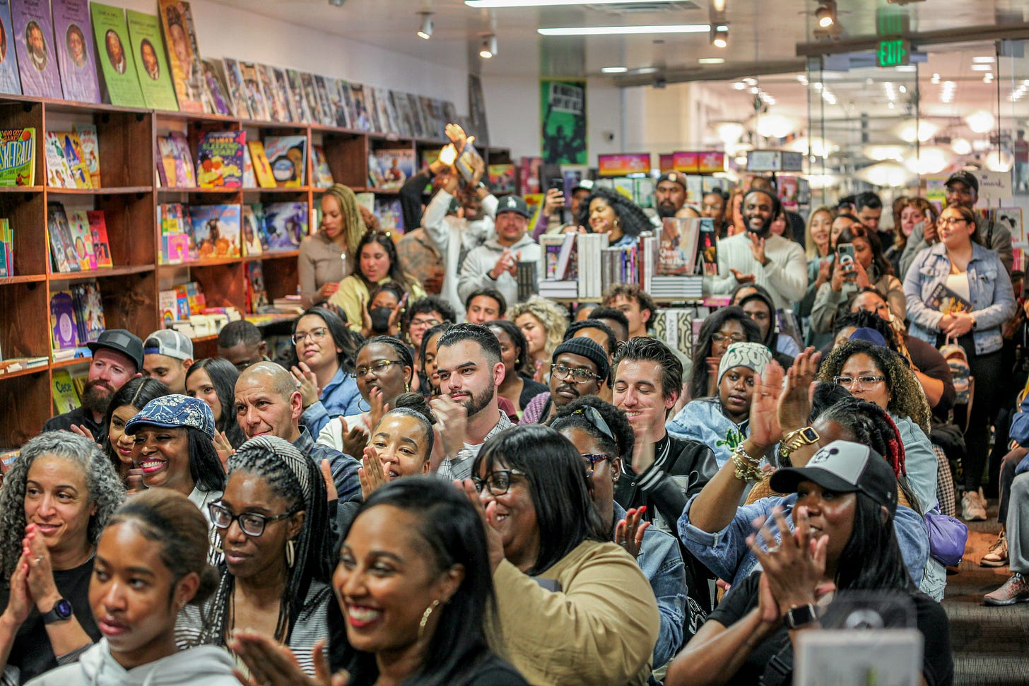 A large crowd gathered inside Malik Books for a community author event A large crowd gathered inside Malik Books for a community author event