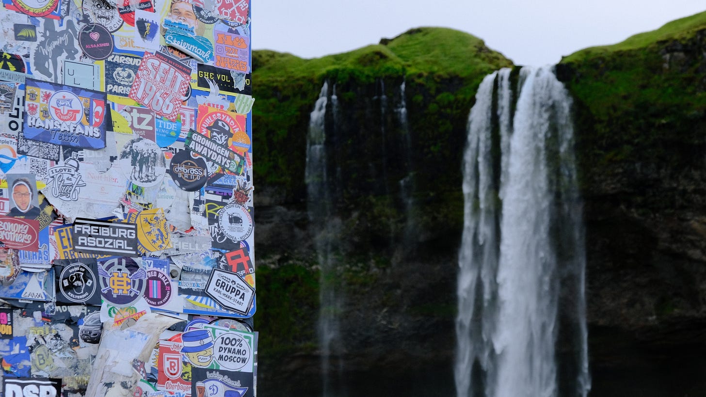 A sign with stickers on it next to a waterfall

AI-generated content may be incorrect.
