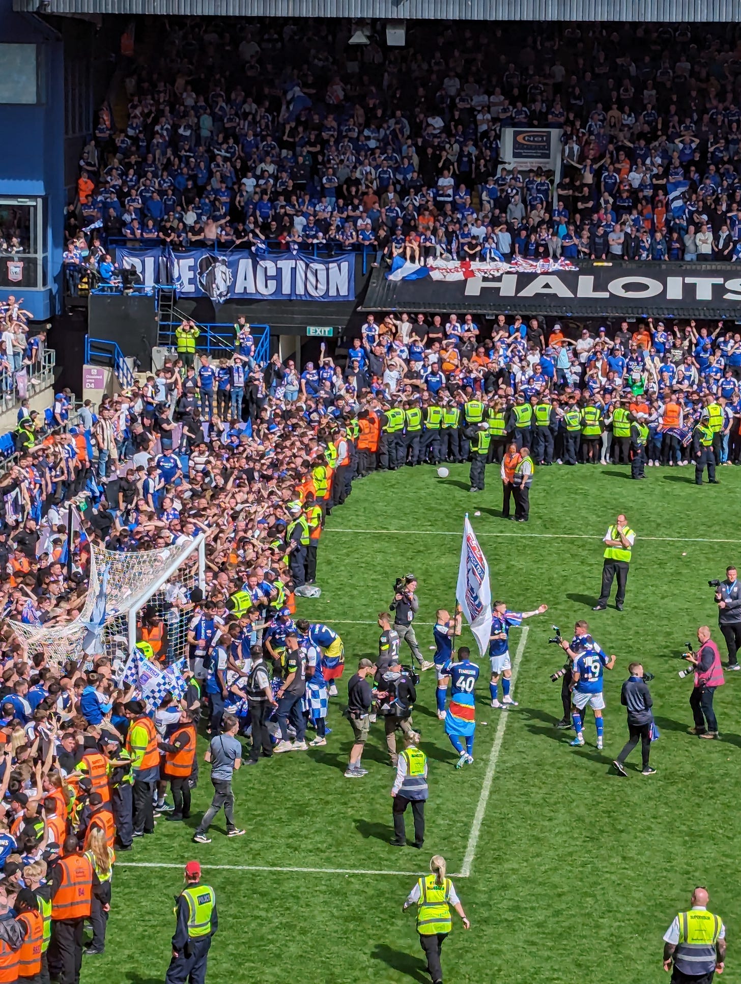 Ipswich players gather for a photo in front of the North Stand goal with a horde of pitch invaders behind them