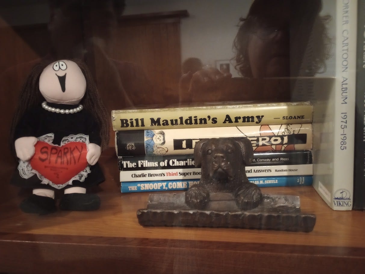 Books, statuette of dog, and small doll labeled Sparky Books, statuette of dog, and small doll labeled Sparky